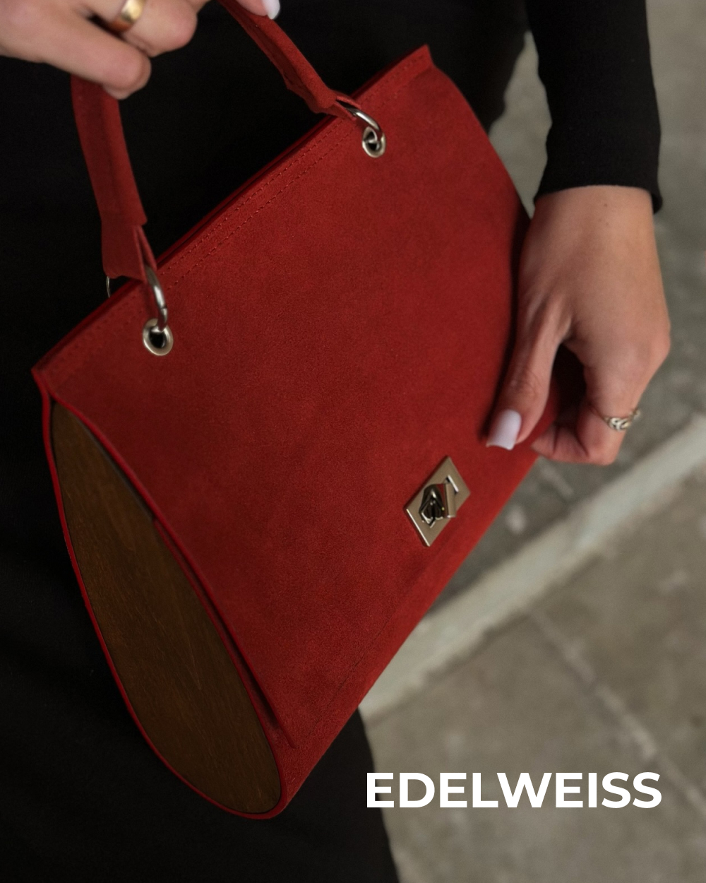 У Edelweiss – строгая геометричная сумка из красной замши с деревянными боковыми вставками. Сочетание насыщенного цвета и разных фактур делает модель заметной даже в самом лакон…